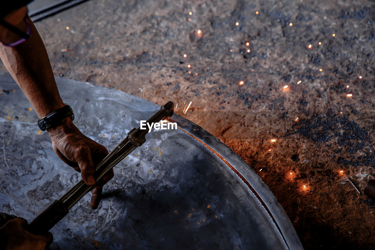 Close-up of man working on metal