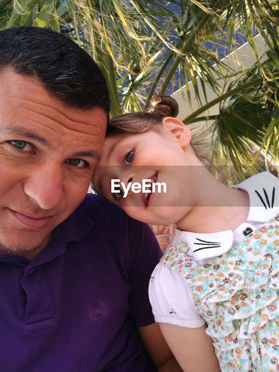 Close-up portrait of smiling father and cute daughter