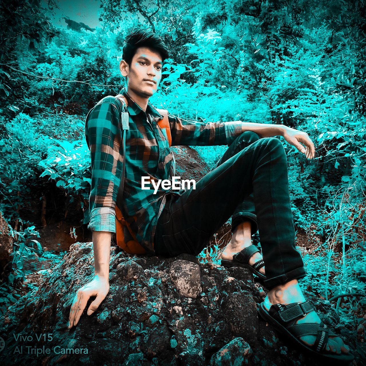 PORTRAIT OF YOUNG MAN SITTING ON LAND
