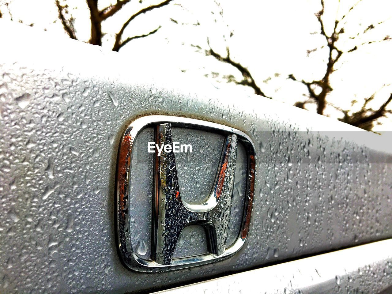 CLOSE-UP OF VINTAGE CAR ON SIDE-VIEW MIRROR AGAINST SKY