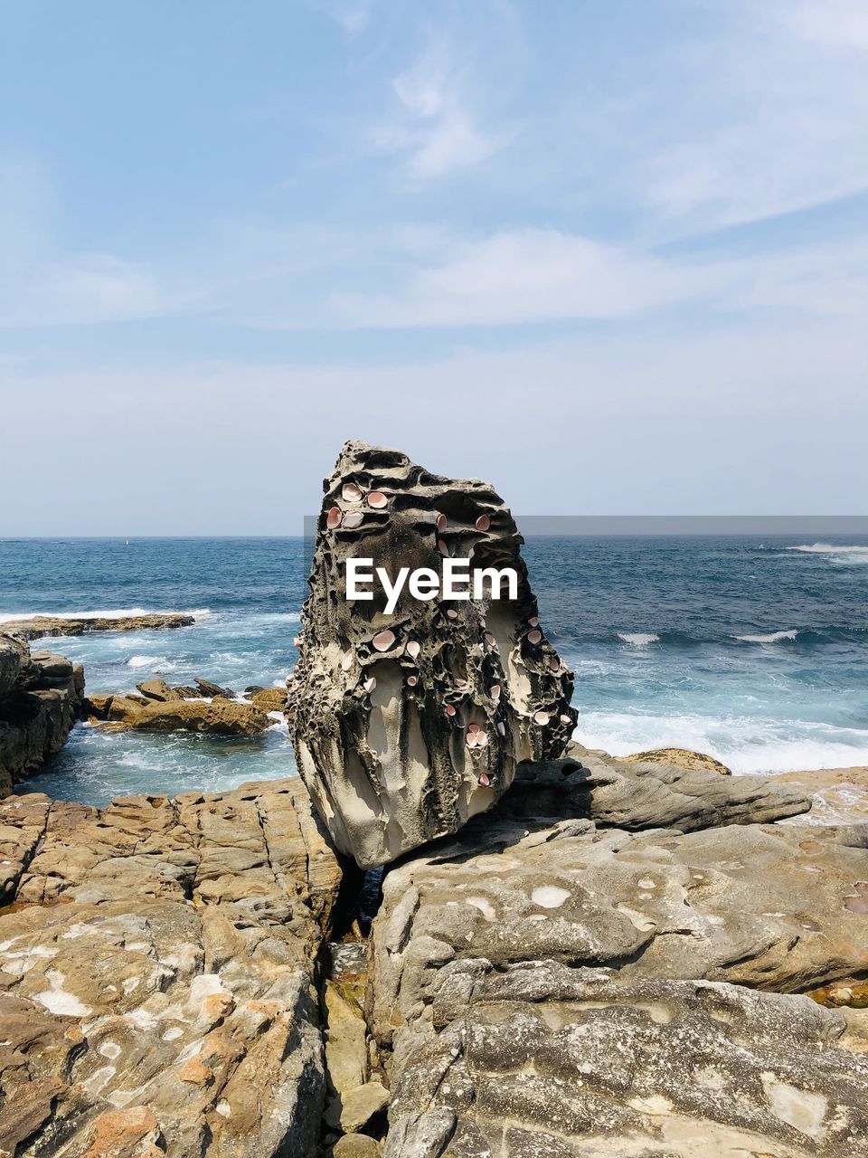 Scenic view of rocks on beach against sky