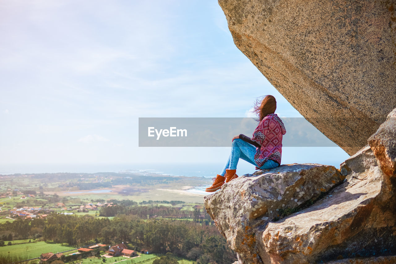 MAN LOOKING AT VIEW OF ROCK FORMATION