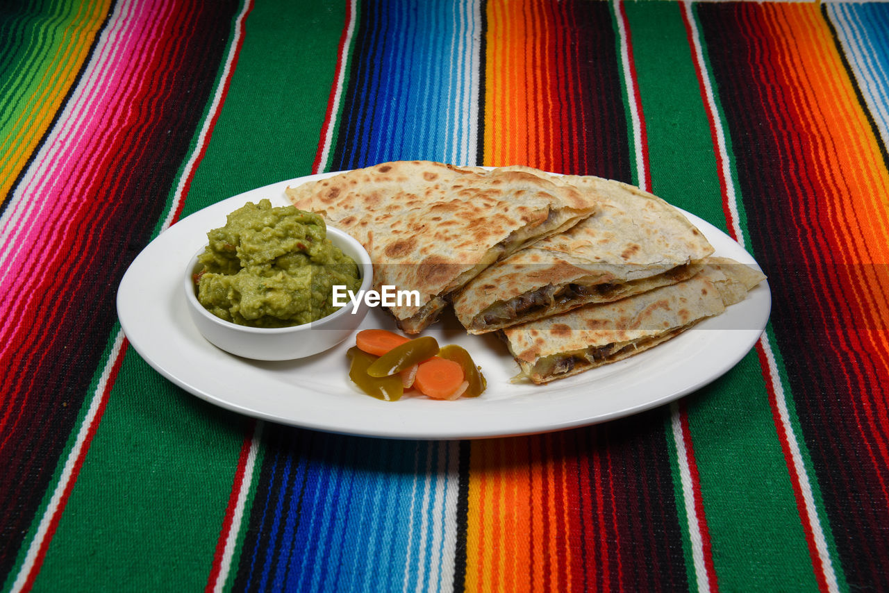 A delicious cheese and beef quesadilla on a plate.