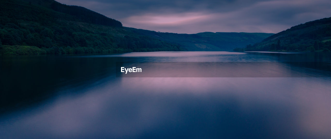 Scenic view of river amidst mountains against sky