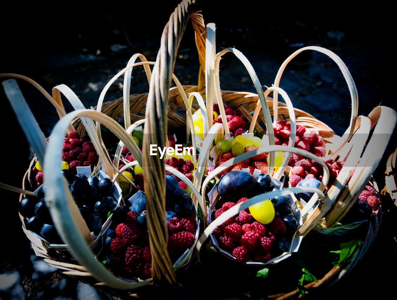 CLOSE-UP OF FRUITS IN BASKET WITH RED BERRIES