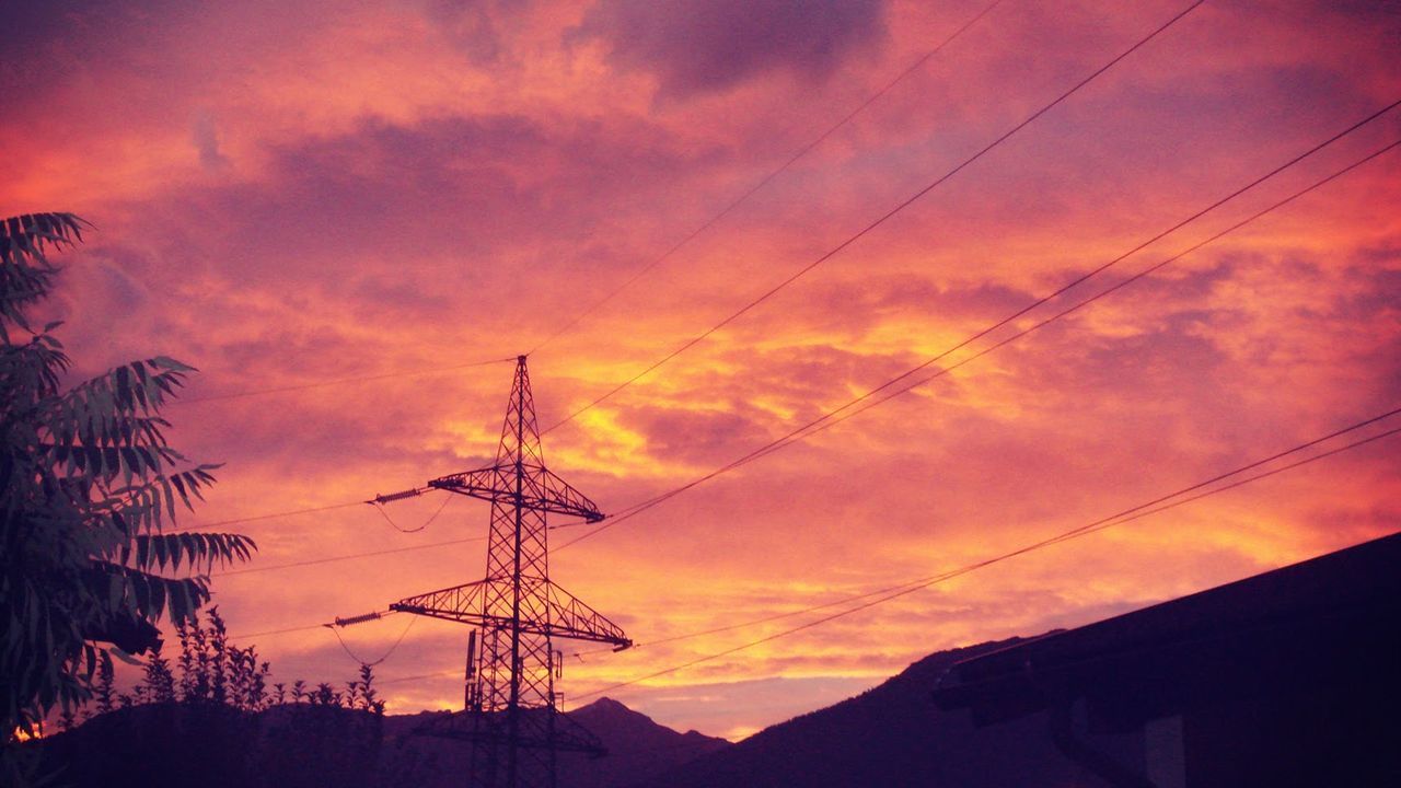 LOW ANGLE VIEW OF ELECTRICITY PYLONS AT SUNSET