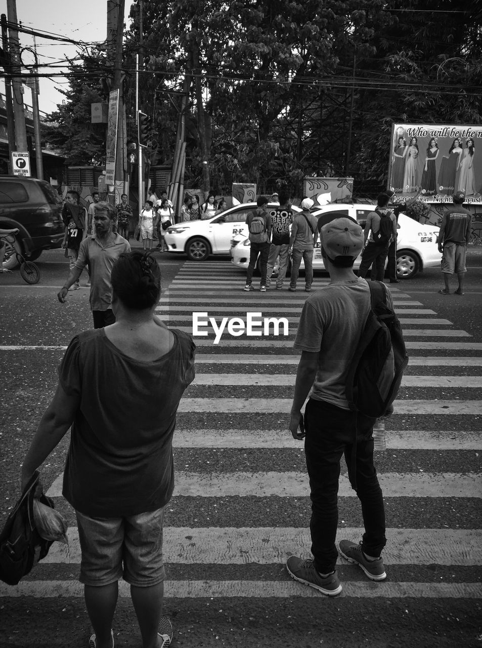 REAR VIEW OF PEOPLE WALKING ON STREET