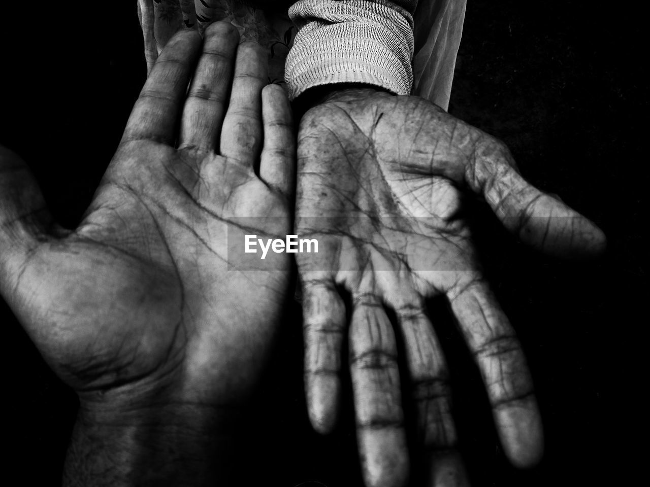 Close-up of messy hands against black background