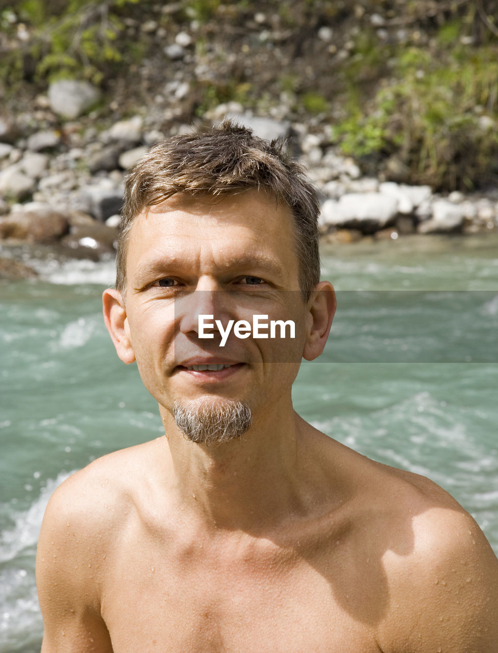 Portrait of smiling mature man against river at whiteswan lake provincial park