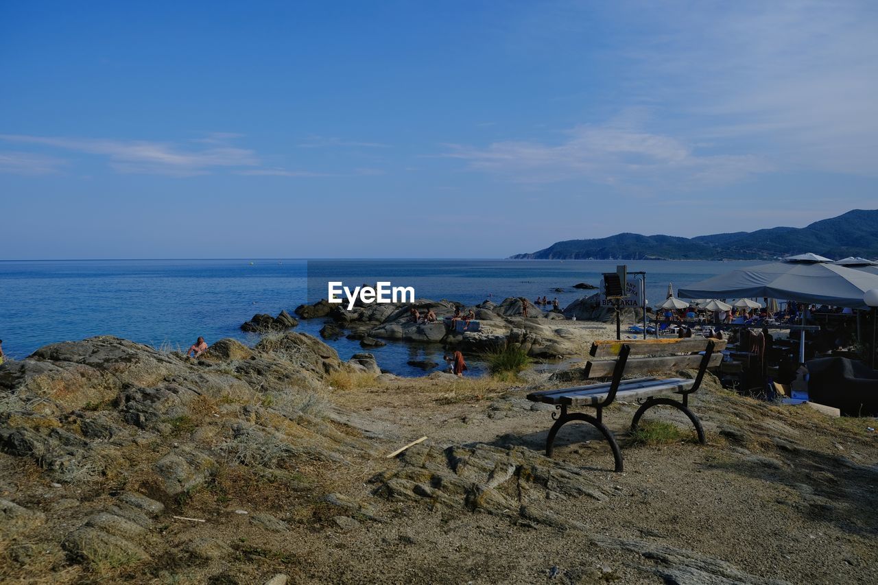 sky, sea, water, beach, land, nature, coast, scenics - nature, body of water, ocean, beauty in nature, shore, horizon over water, horizon, day, tranquility, vacation, tranquil scene, cloud, chair, bay, group of people, outdoors, travel destinations, travel, holiday, non-urban scene, trip, architecture, blue, sand, seat, idyllic, tourism, large group of people, crowd