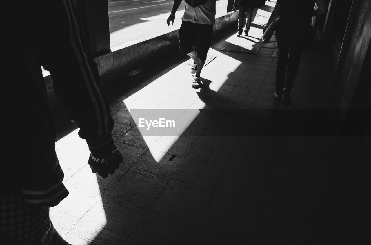 LOW SECTION OF PEOPLE WALKING ON CORRIDOR