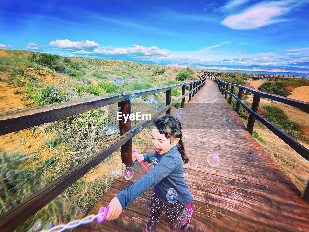 Rear view of woman walking on footbridge