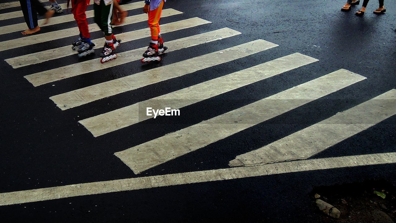 Low section of people roller skating on street