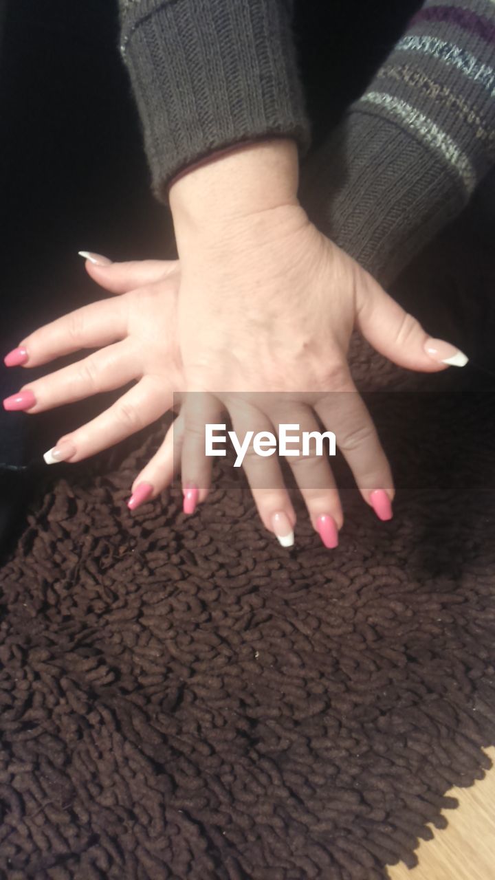 LOW SECTION OF WOMAN WITH HANDS ON HUMAN FEET
