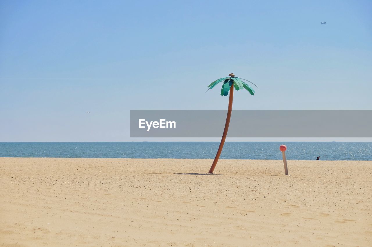 Scenic view of beach against clear blue sky