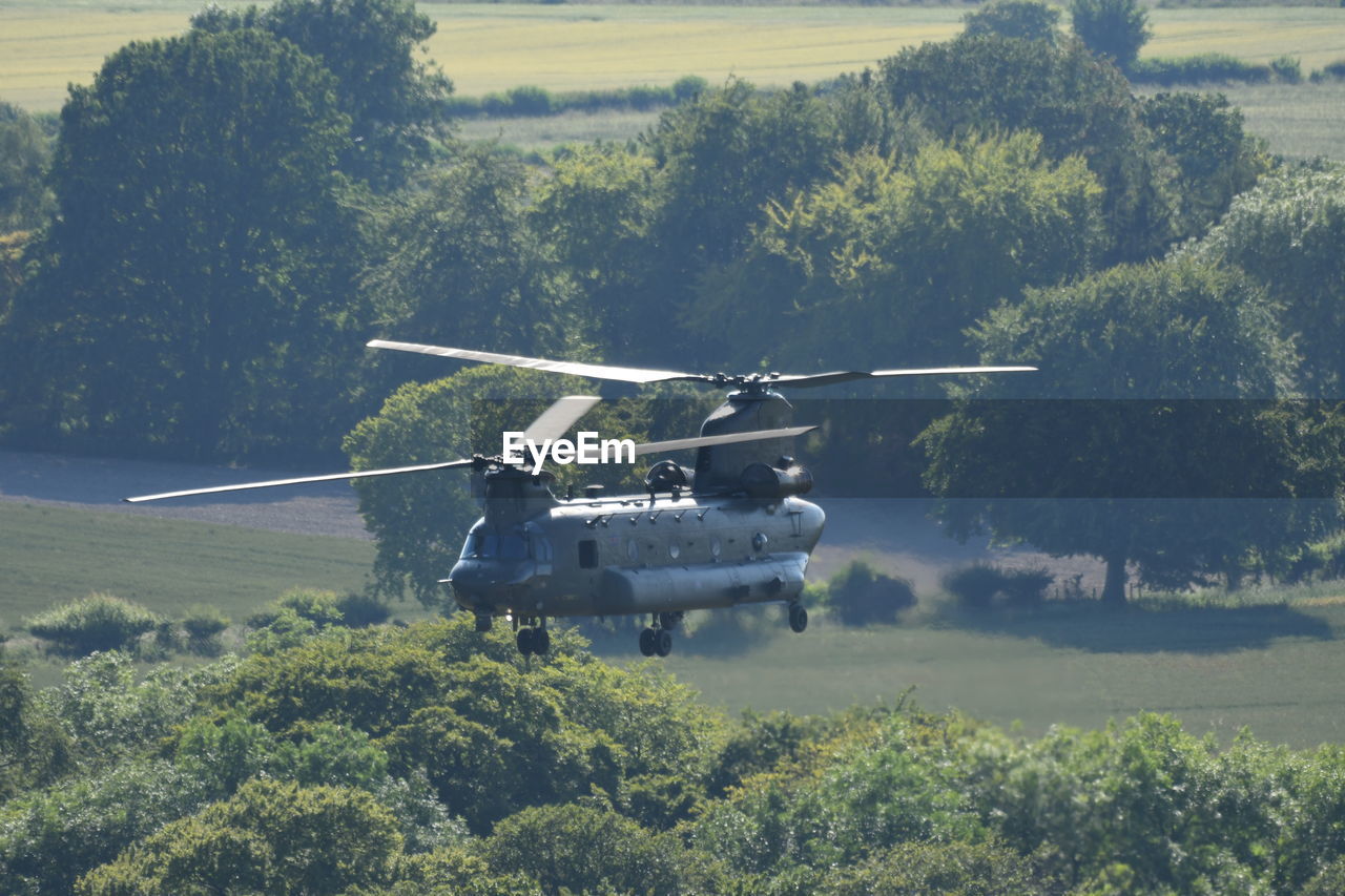 AIRPLANE FLYING OVER FIELD