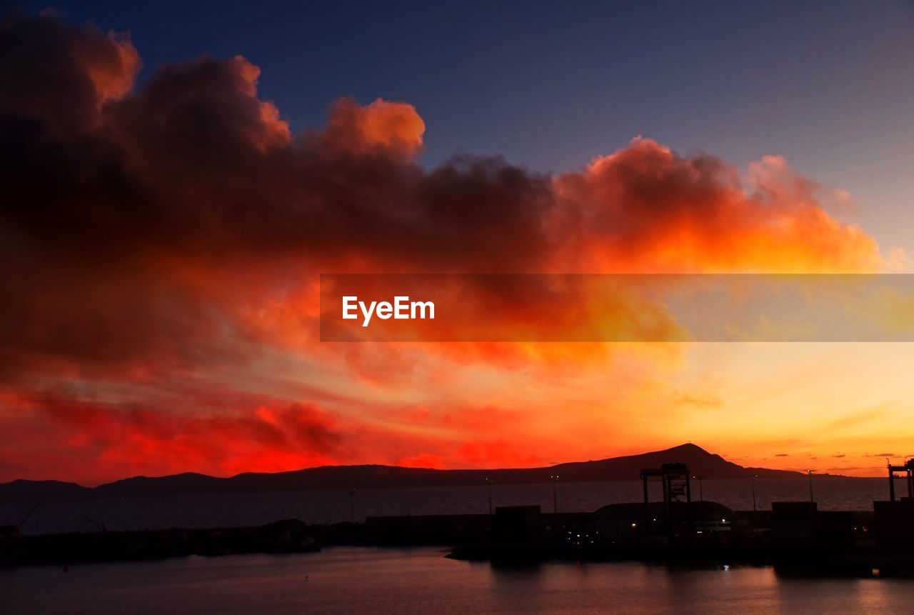 afterglow, sky, sunset, dawn, water, cloud, red sky at morning, beauty in nature, evening, nature, mountain, horizon, architecture, dramatic sky, sea, no people, scenics - nature, night, environment, landscape, orange color, travel destinations, outdoors, city, silhouette, built structure, tranquility, red, building exterior, reflection, land