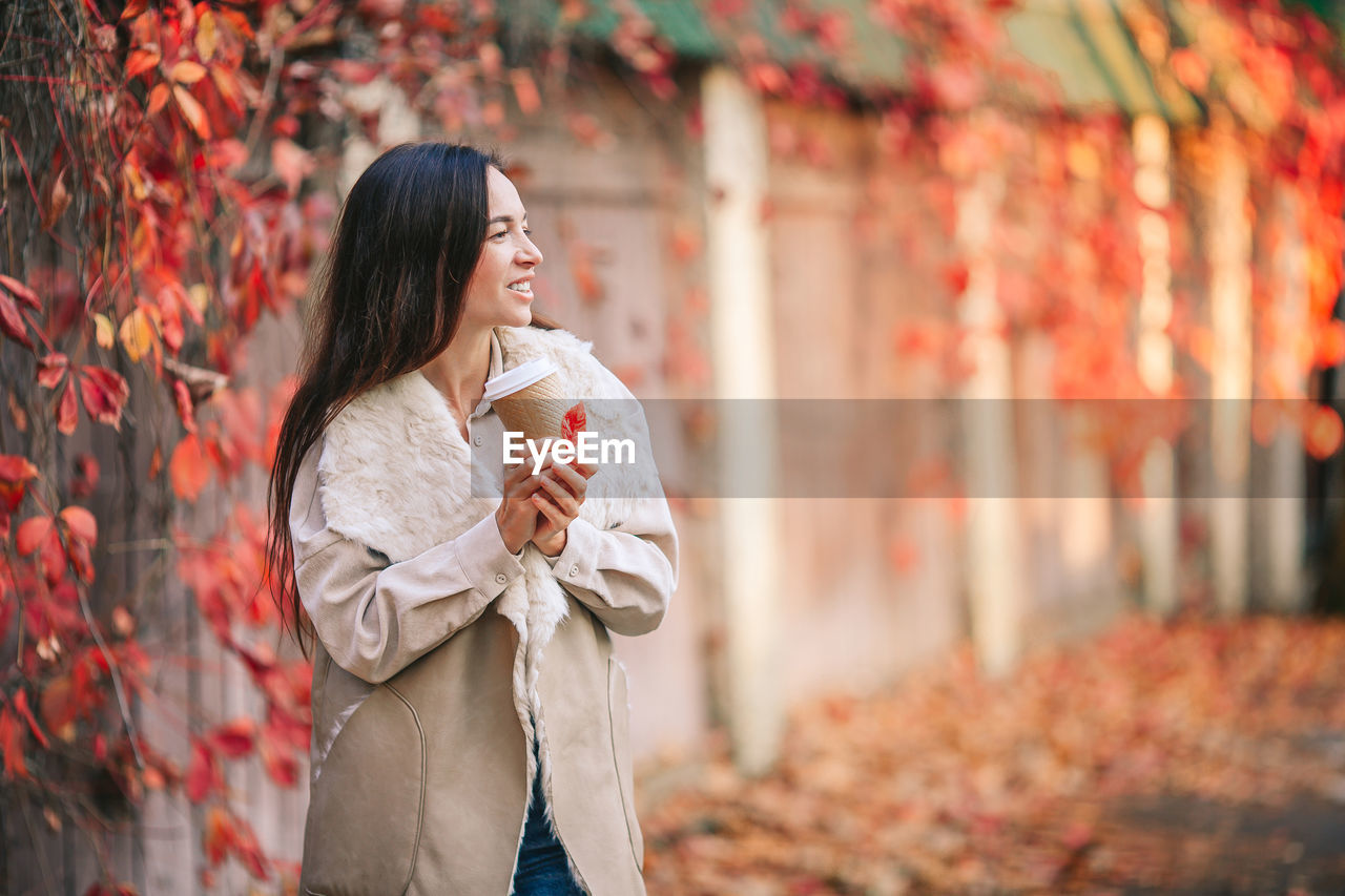 WOMAN STANDING IN AUTUMN LEAF