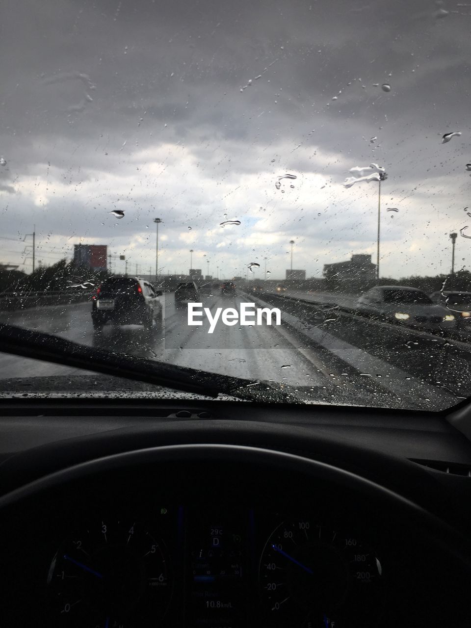 CARS ON ROAD SEEN THROUGH WET WINDSHIELD