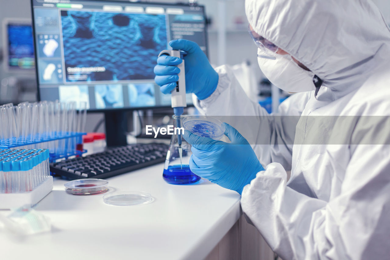 midsection of scientist working on table