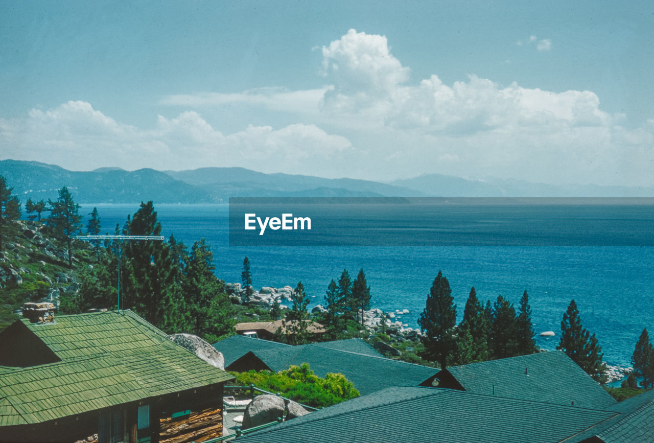 high angle view of buildings by sea against sky