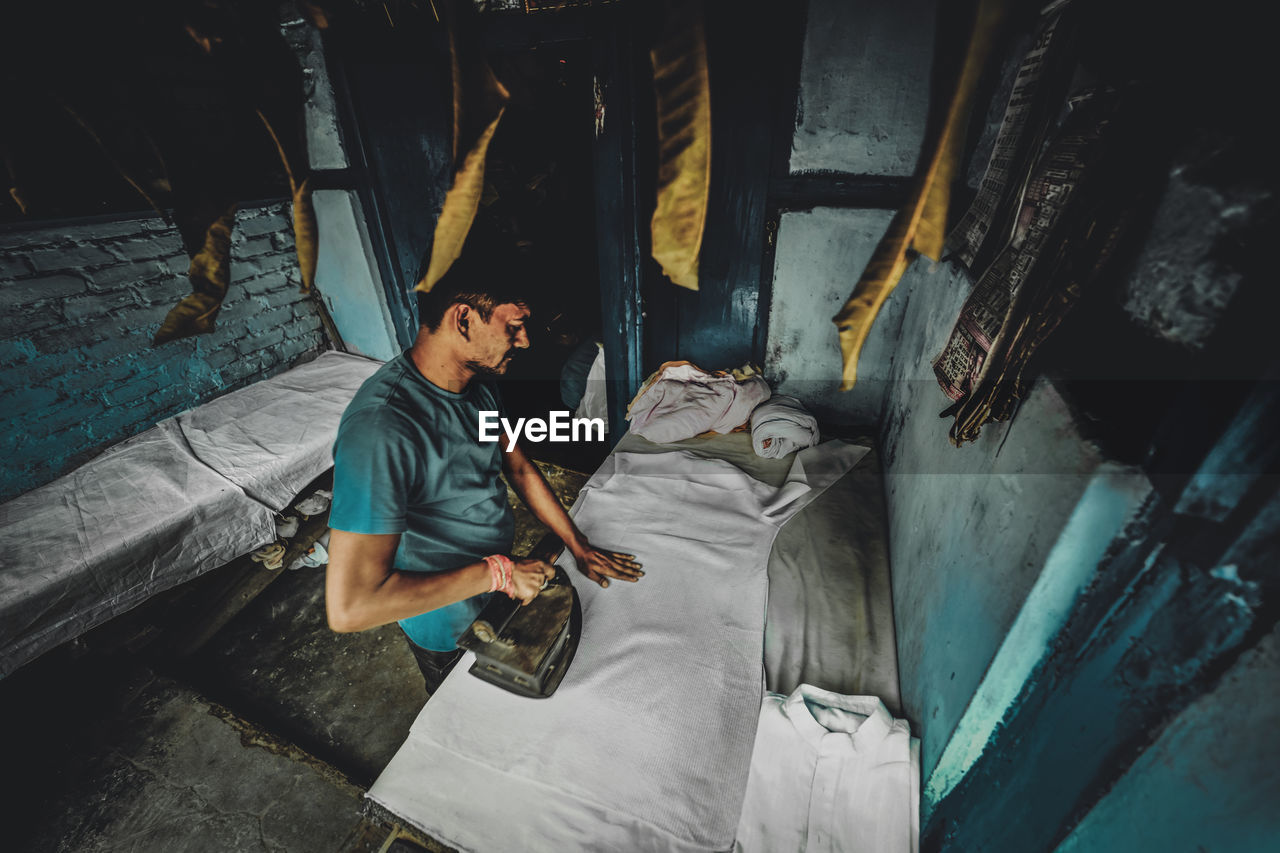 HIGH ANGLE VIEW OF MAN WORKING ON FLOOR IN BUILDING