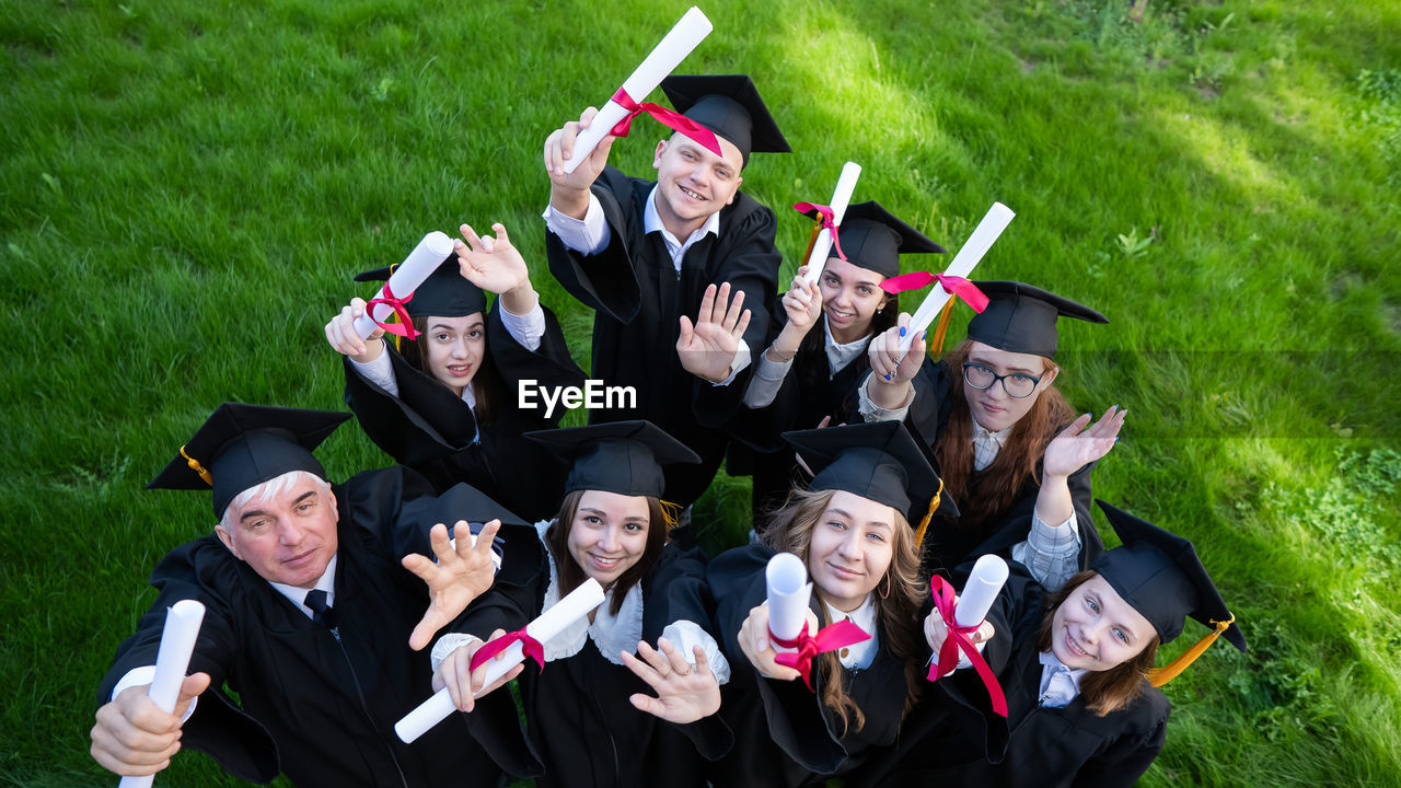 rear view of students standing on field