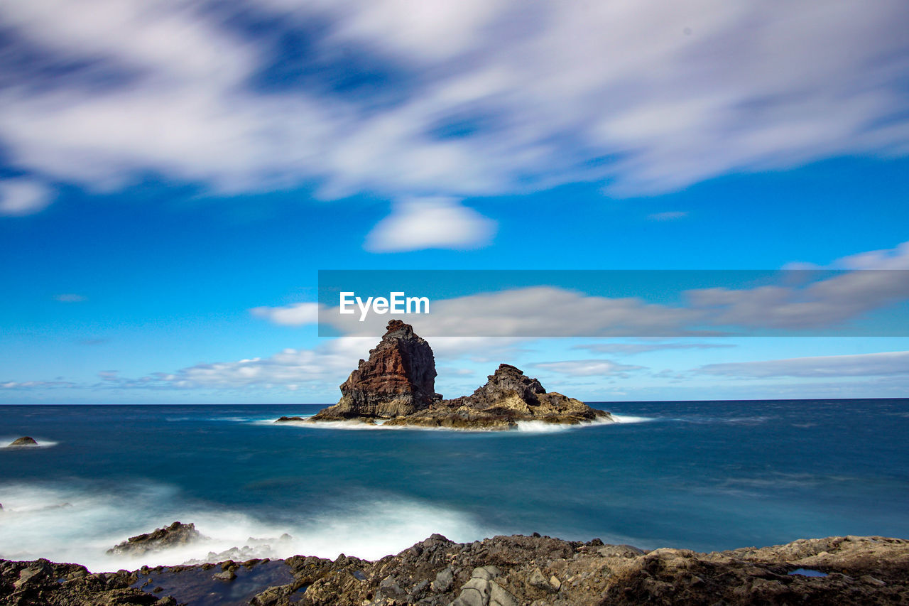 ROCK FORMATIONS IN SEA AGAINST SKY