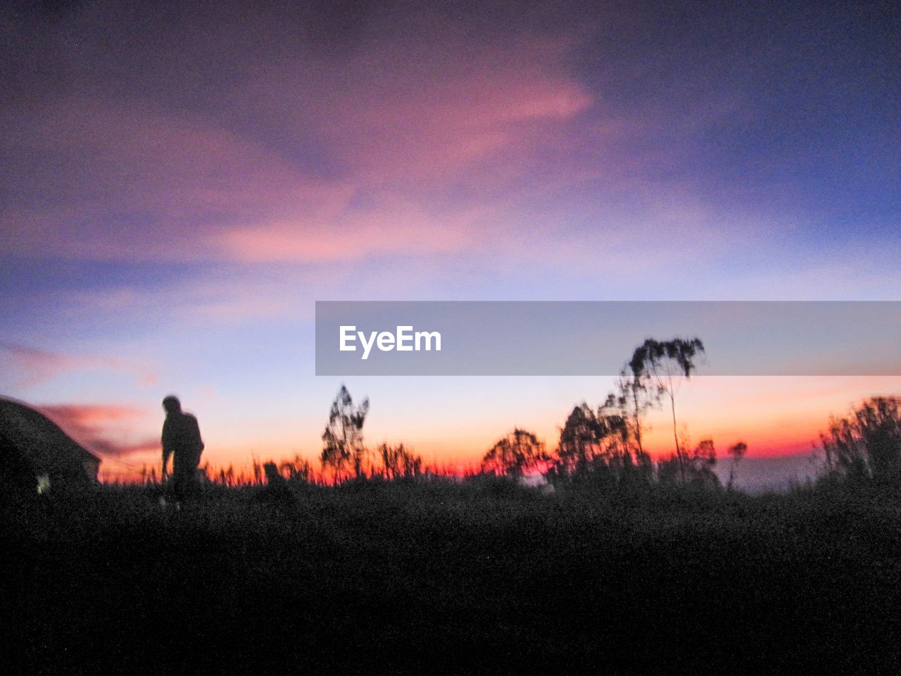 SILHOUETTE MAN STANDING ON FIELD AGAINST ORANGE SKY