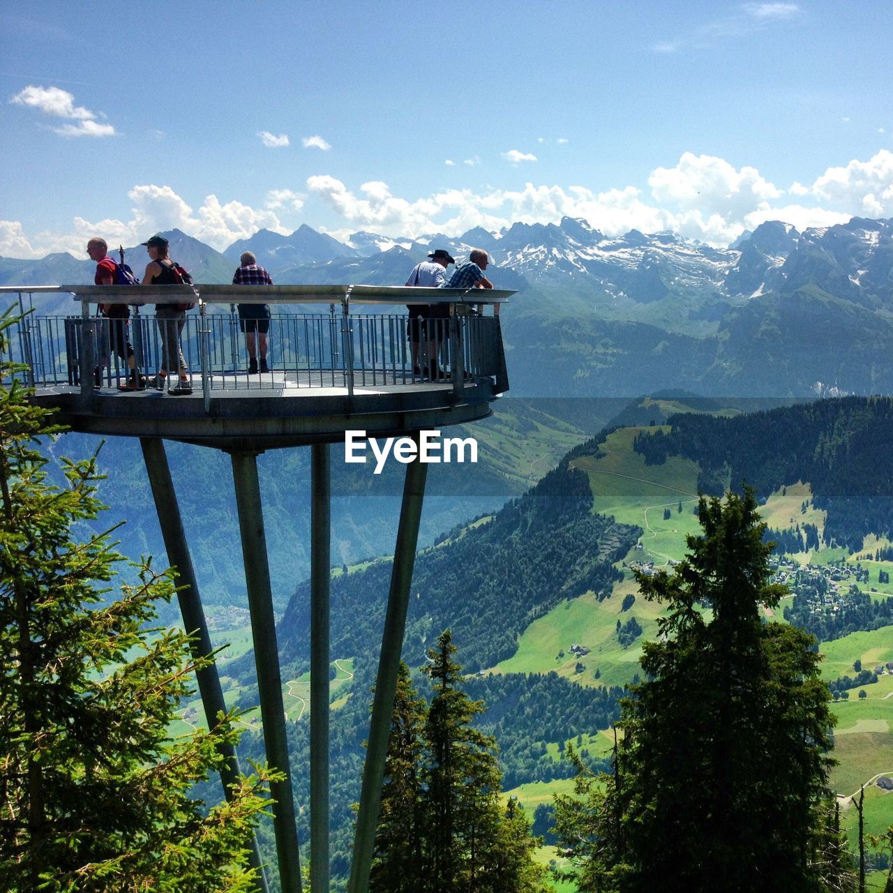 People at observation point against swiss alps