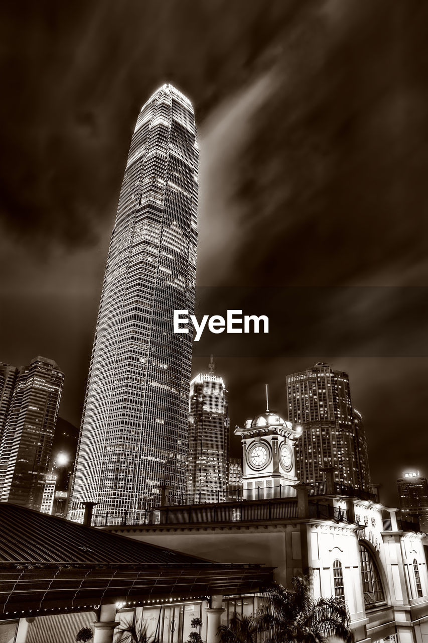 Low angle view of illuminated buildings against cloudy sky