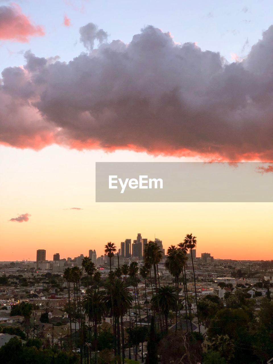 View of buildings against cloudy sky during sunset