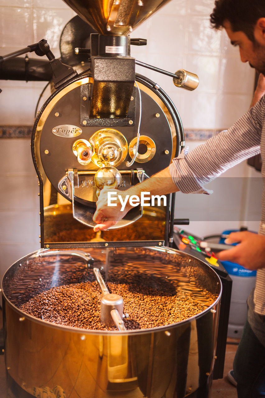 Barista preparing coffee in machinery at cafe