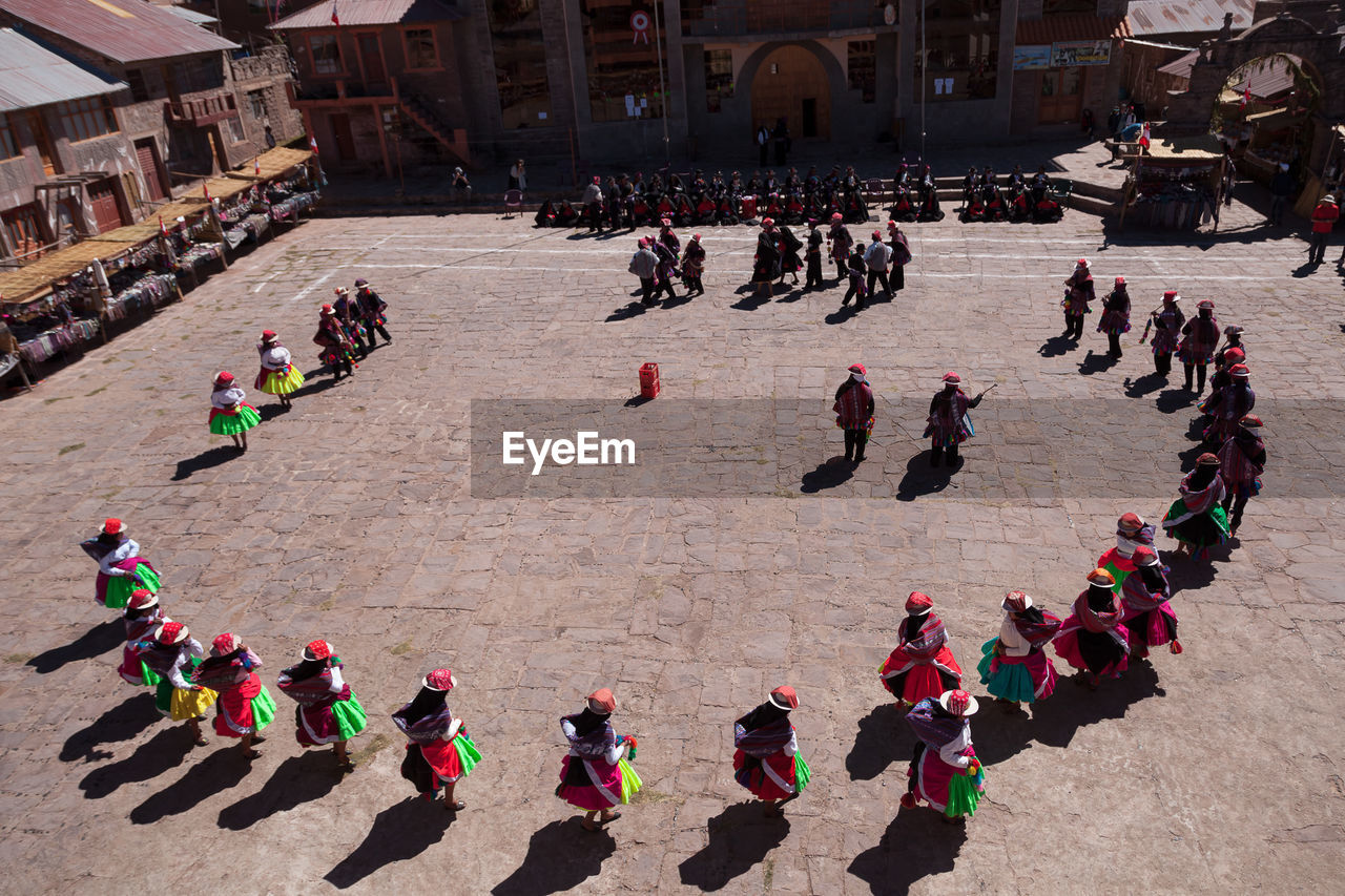 HIGH ANGLE VIEW OF GROUP OF PEOPLE IN TOWN SQUARE