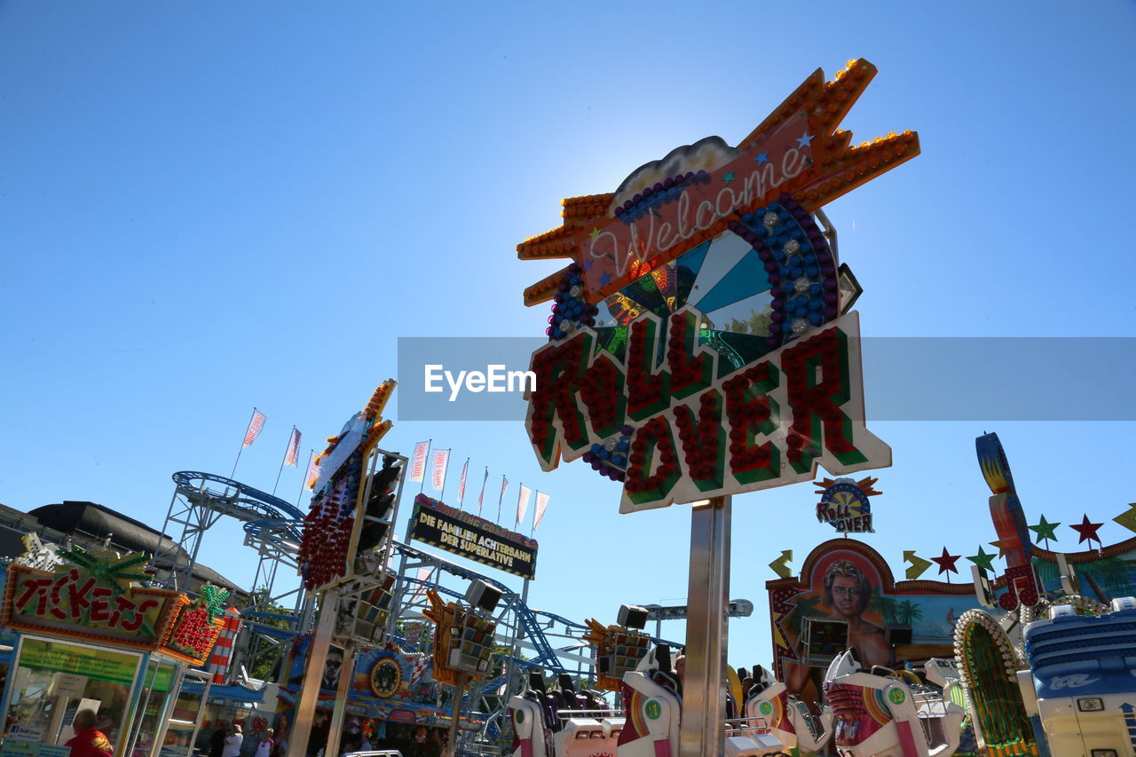 LOW ANGLE VIEW OF CAROUSEL AGAINST CLEAR BLUE SKY