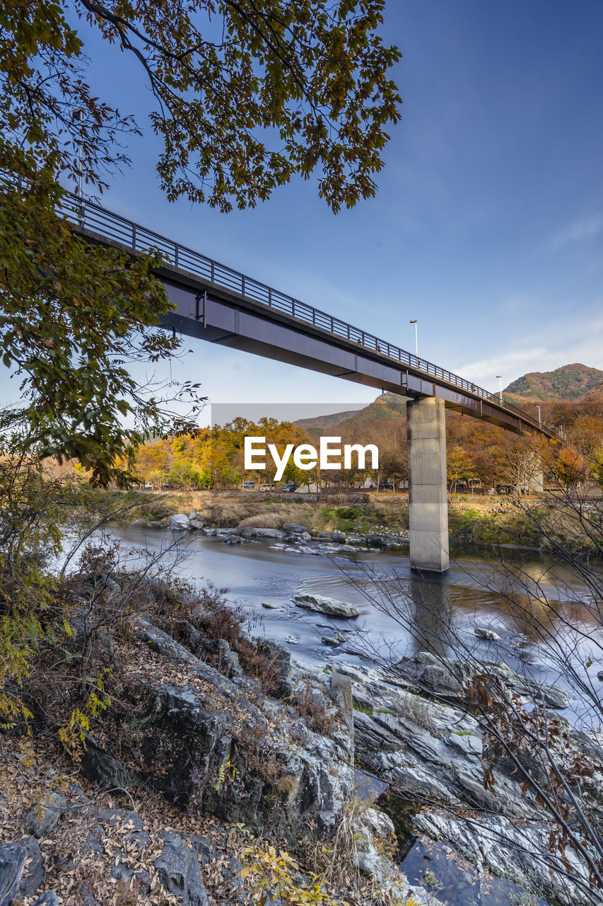 Low angle view of bridge over river against sky