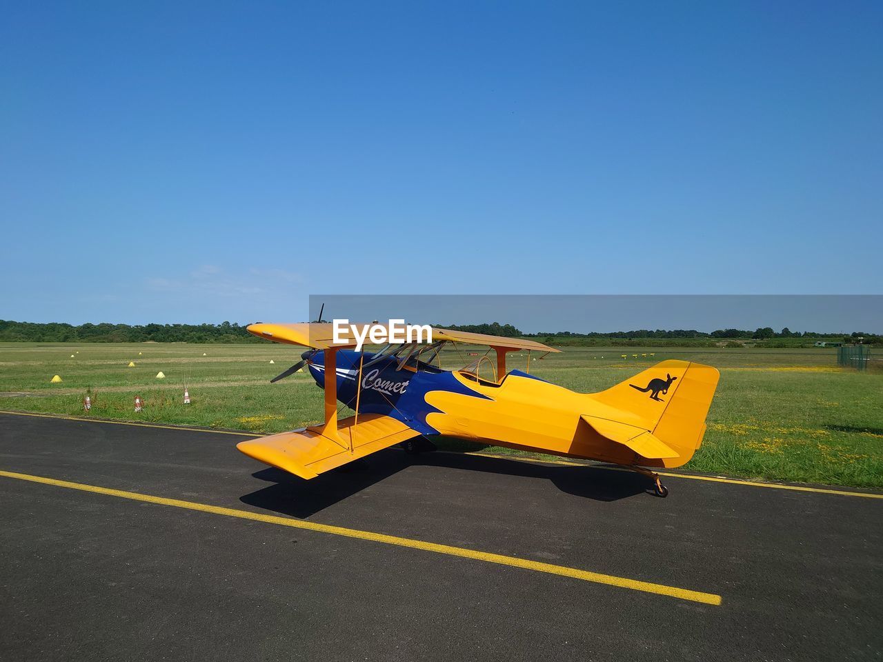 low angle view of airplane on field against clear blue sky