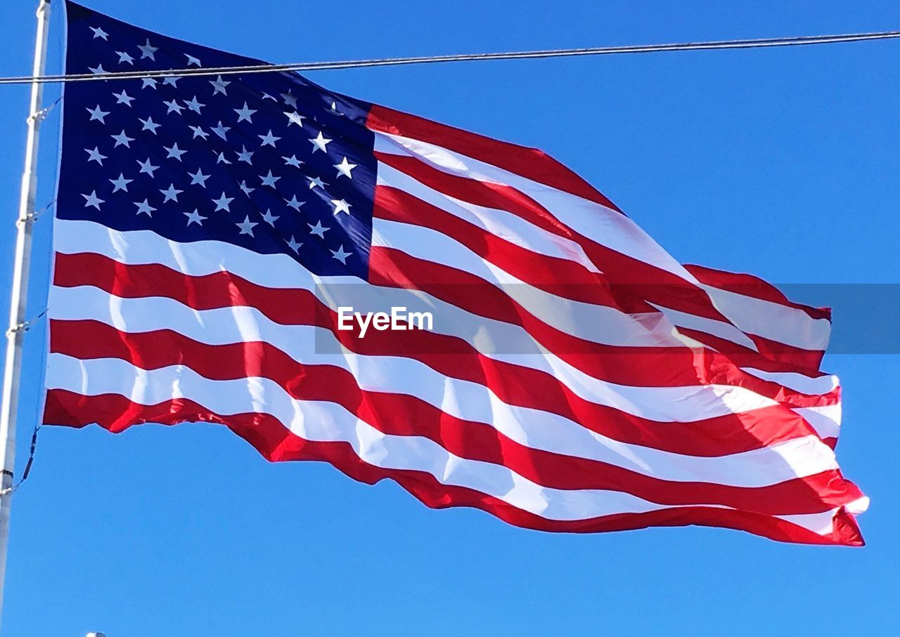 LOW ANGLE VIEW OF FLAG AGAINST BLUE SKY