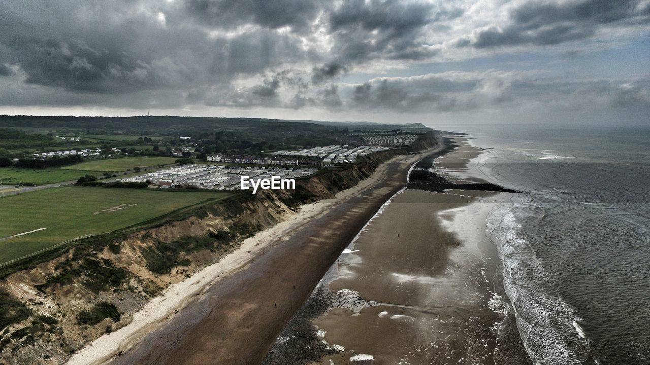 Aerial view of beach against cloudy sky at cromer