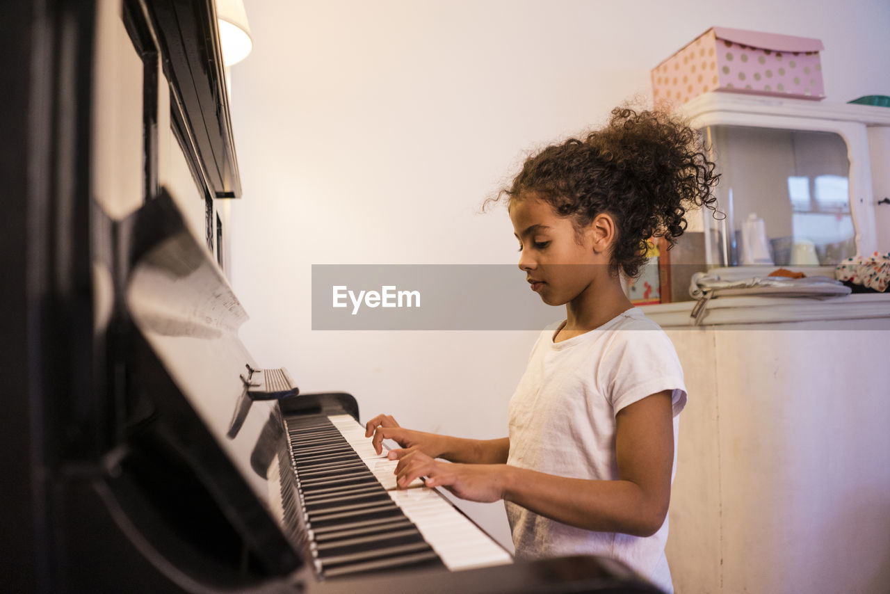 Girl practicing piano at home