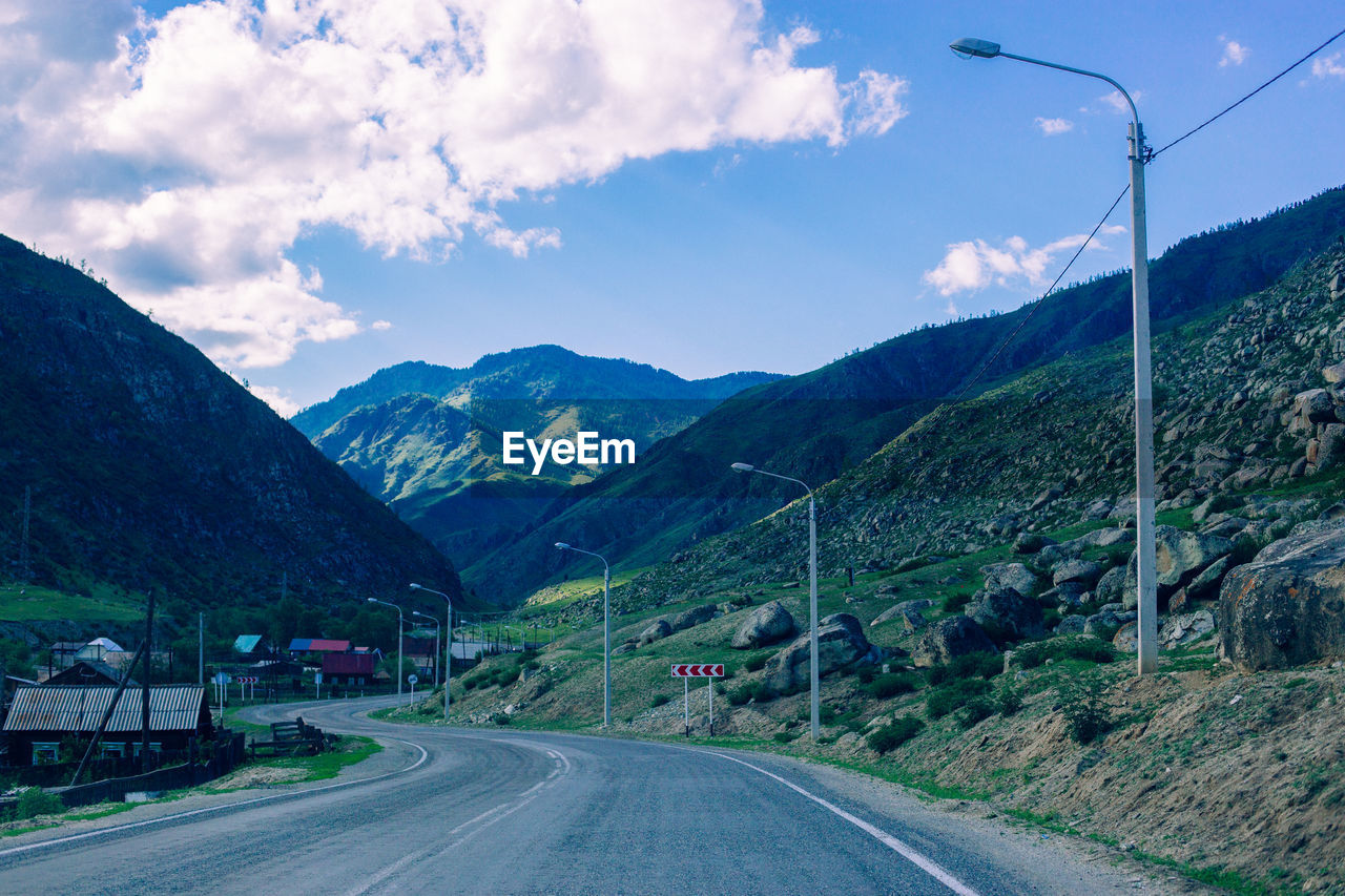 Ski lift by mountains against sky