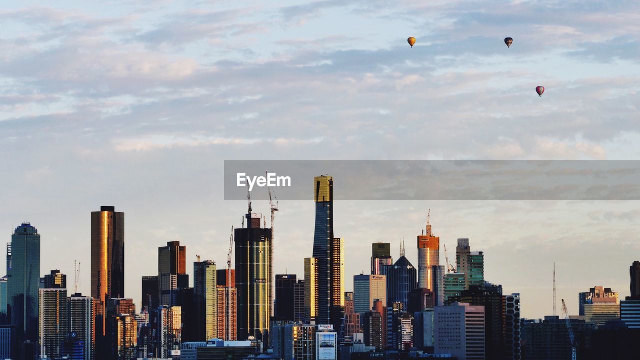 Skyscrapers in melbourne city against cloudy sky