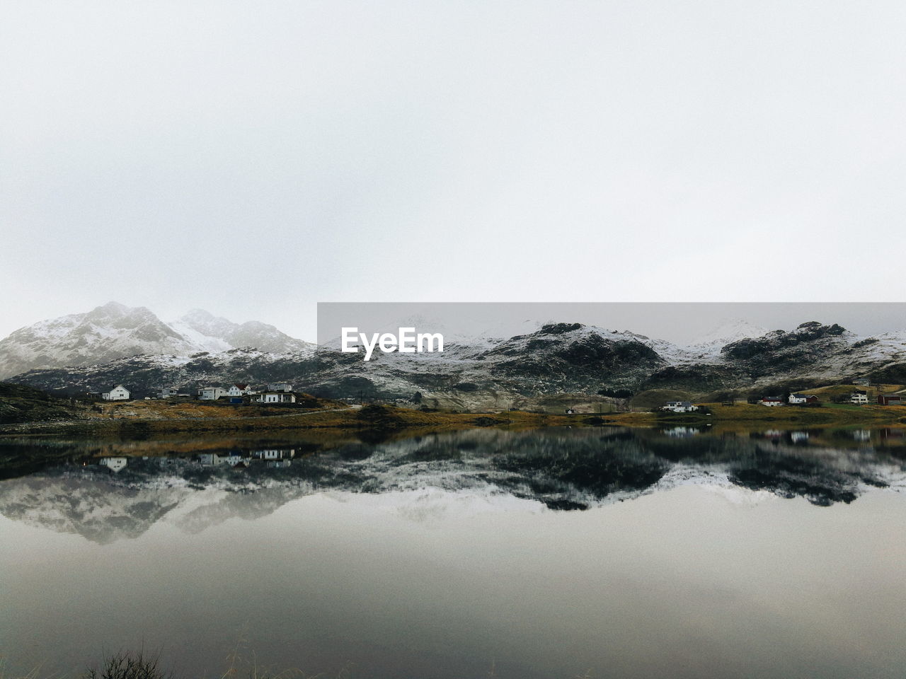 Scenic view of lake by snowcapped mountain against sky