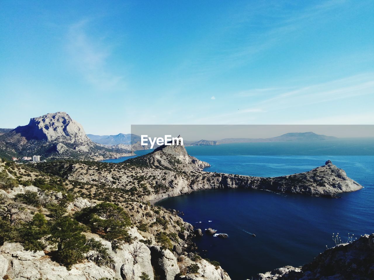 Scenic view of sea and rocks against blue sky