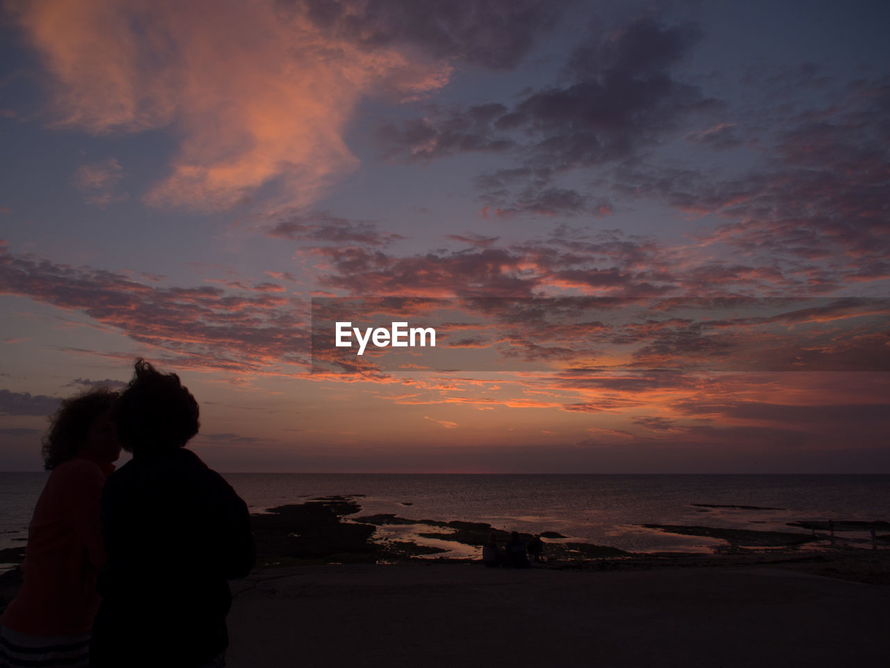 SILHOUETTE MAN ON BEACH AGAINST SKY AT SUNSET