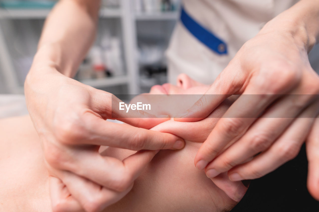 Cosmetic facial massage procedure. close-up of the face of a young woman lying on her back, doing a