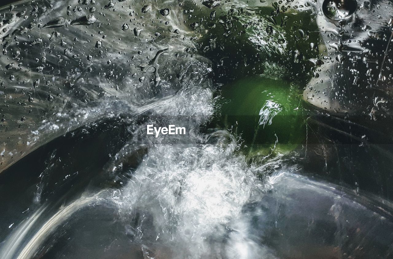 HIGH ANGLE VIEW OF WATER SPLASHING ON SEA