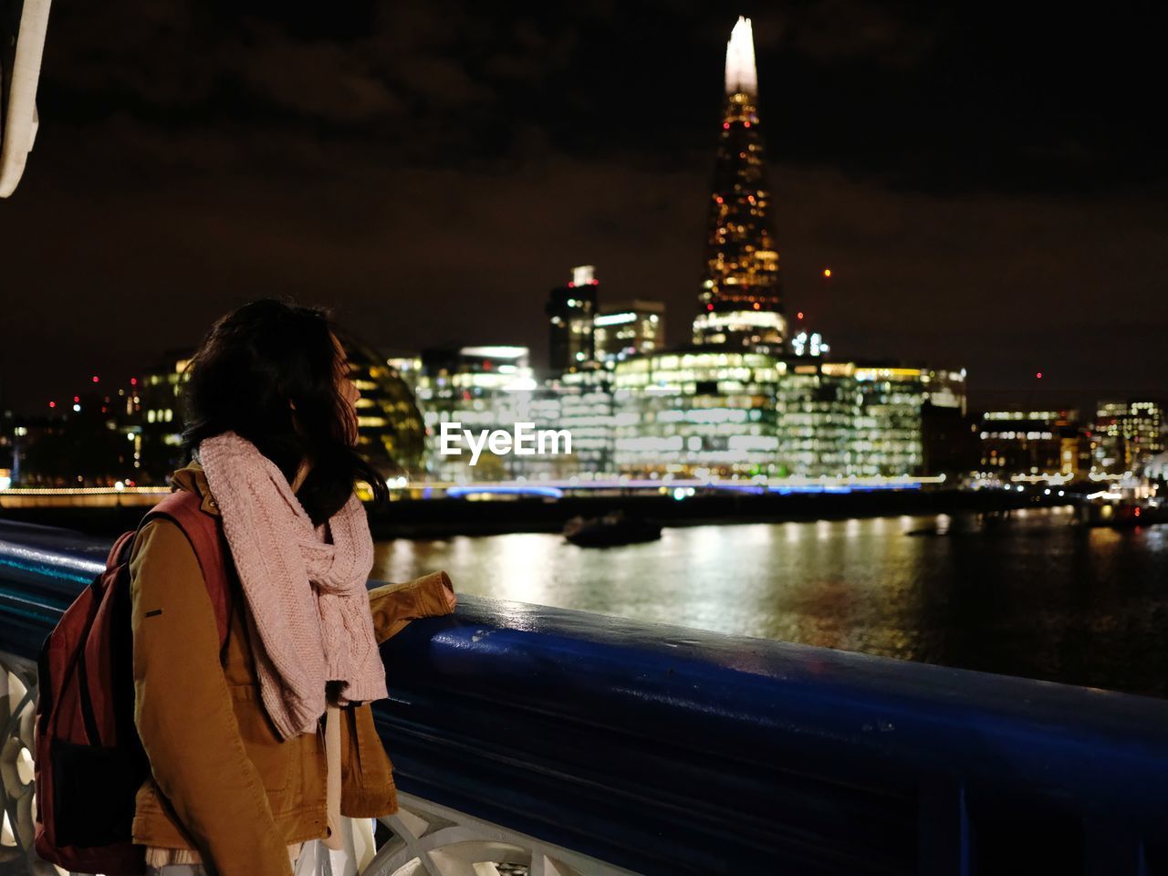 Rear view of woman standing in illuminated city at night