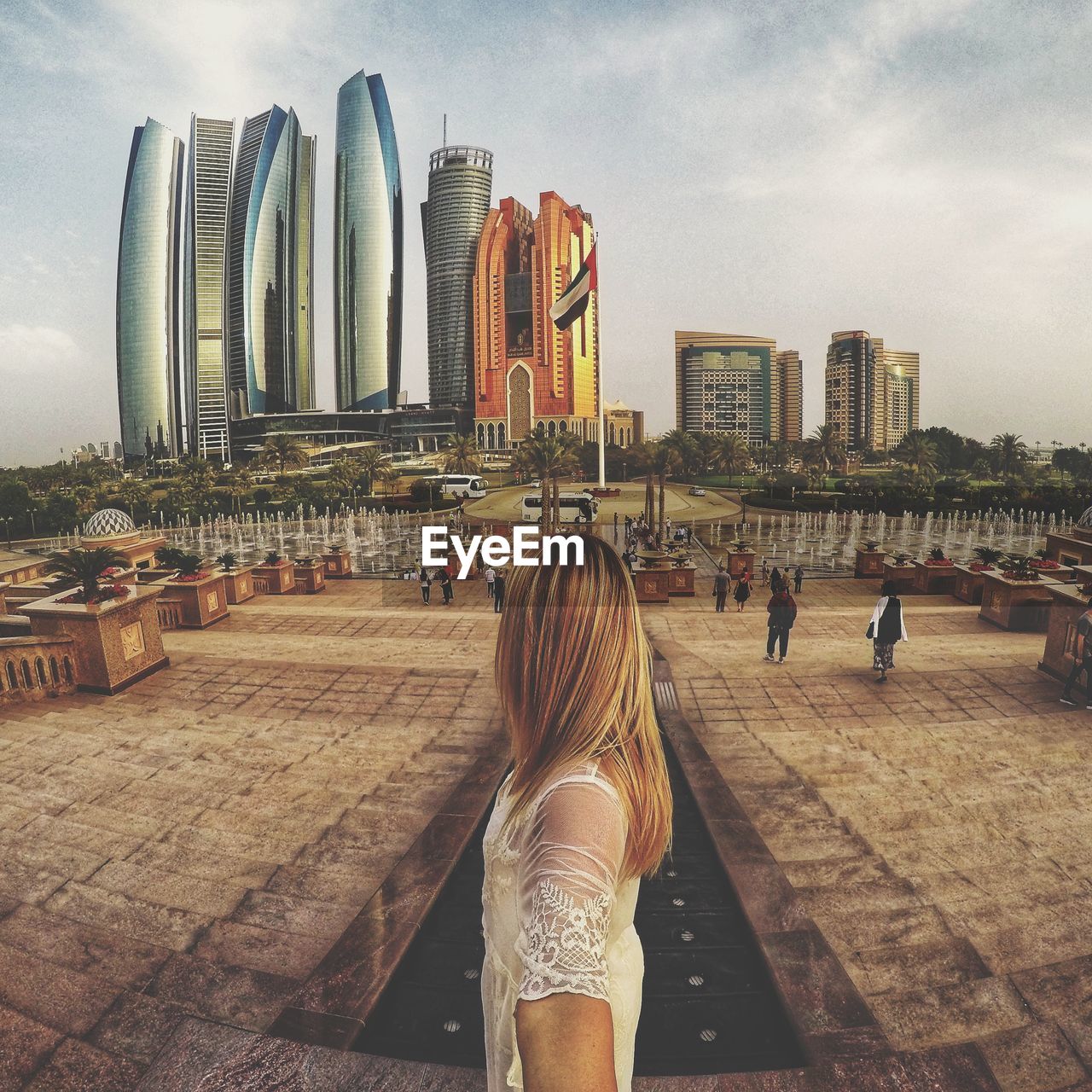 REAR VIEW OF WOMAN WALKING ON MODERN BUILDINGS