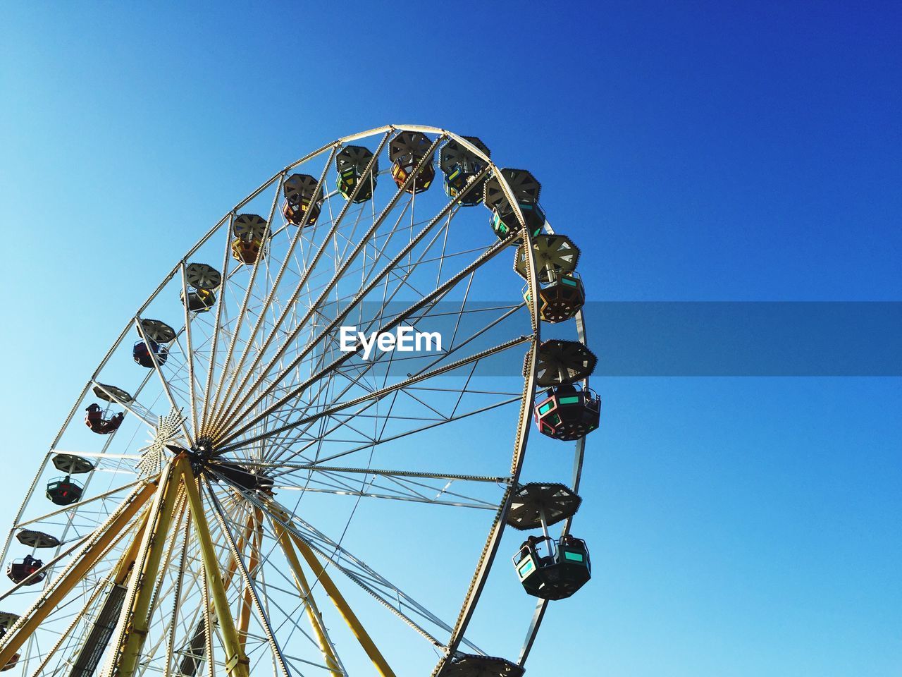 Low angle view of ferris wheel against clear sky